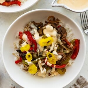 Philly cheesesteak bowl with ground beef, peppers, mushrooms, banana peppers and creamy cheese sauce over rice.