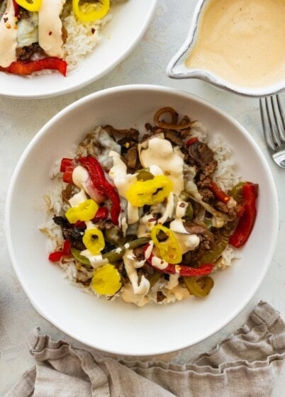 Philly cheesesteak bowl with ground beef, peppers, mushrooms, banana peppers and creamy cheese sauce over rice.