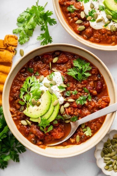 Pumpkin chili topped with avocado, Greek yogurt, pepitas and parsley with cornbread on the side.