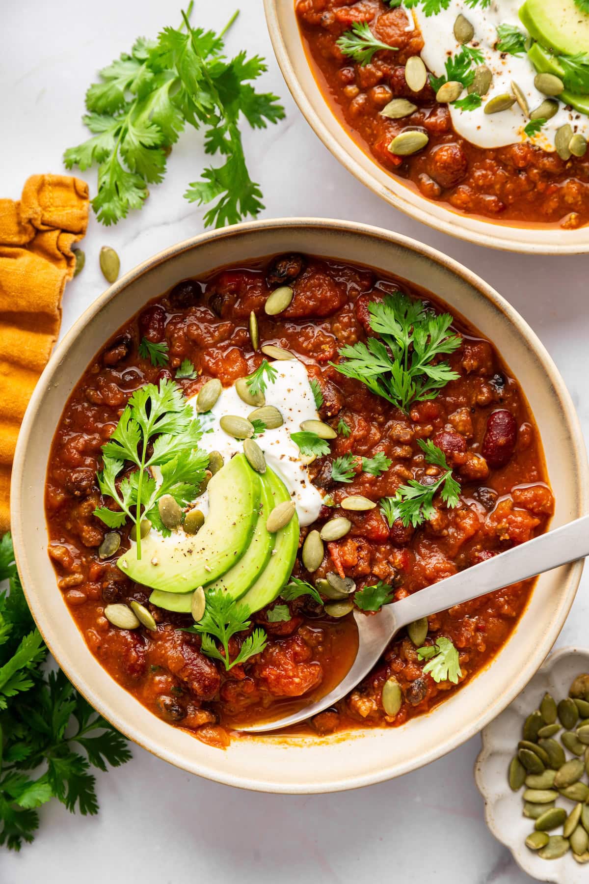 Pumpkin chili topped with avocado, Greek yogurt, pepitas and parsley with cornbread on the side.