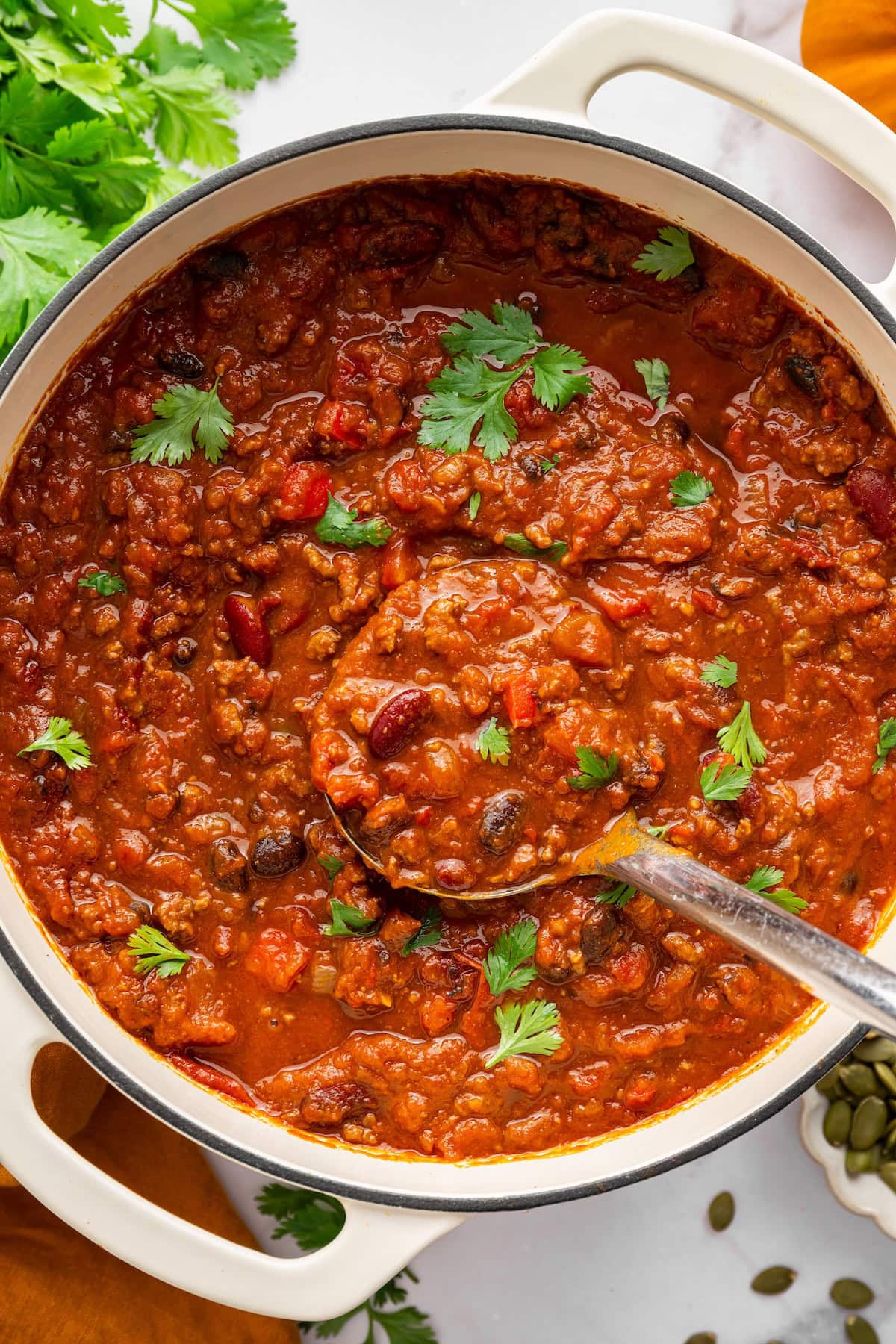 Pumpkin chili topped with fresh parsley in a Dutch oven.