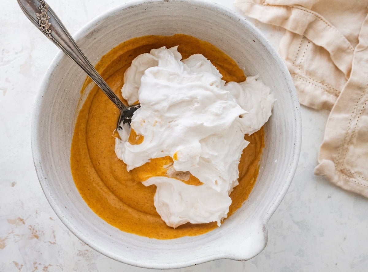 A large mixing bowl with pumpkin fluff dip and truwhip added to it.