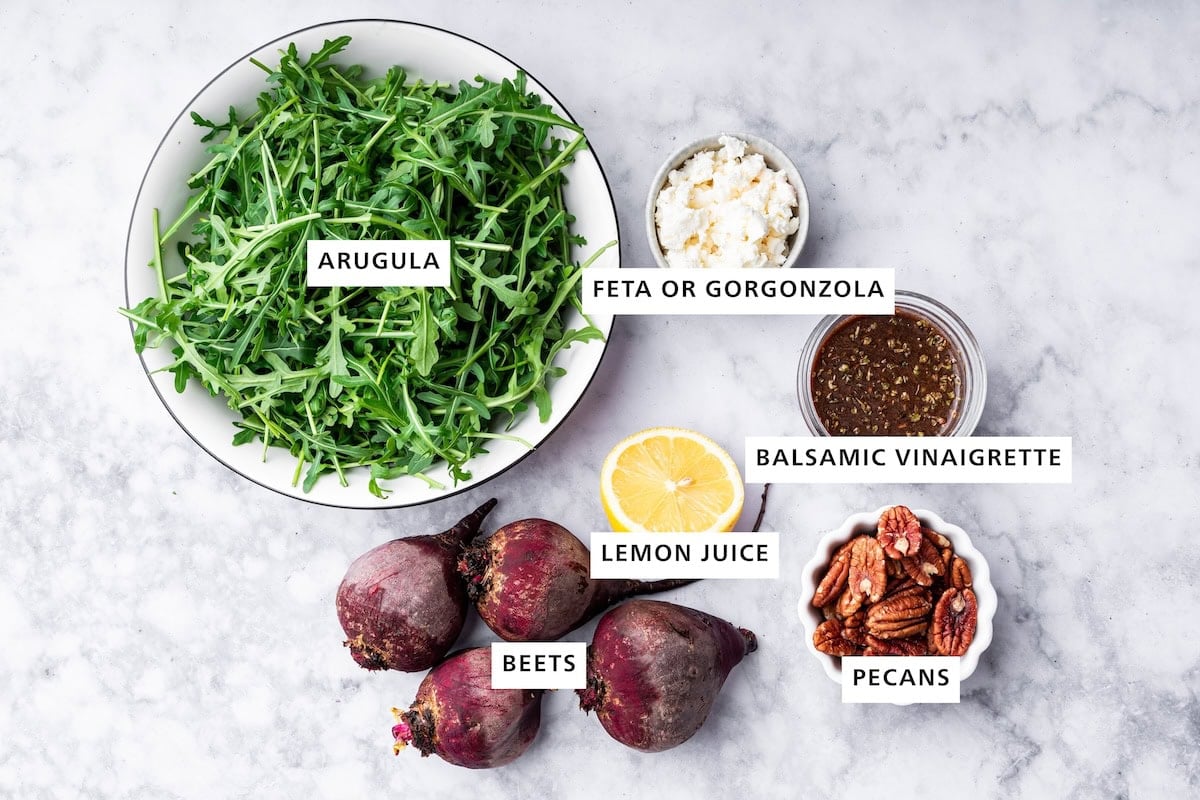 Ingredients measured out to make Beet Salad: beets, arugula, lemon juice, feta, pecans and balsamic vinaigrette.