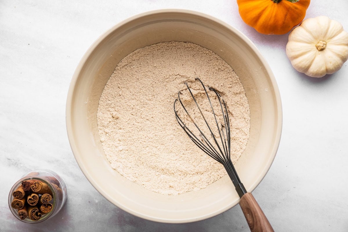 Dry ingredients for high protein pumpkin bread in a mixing bowl with a whisk.