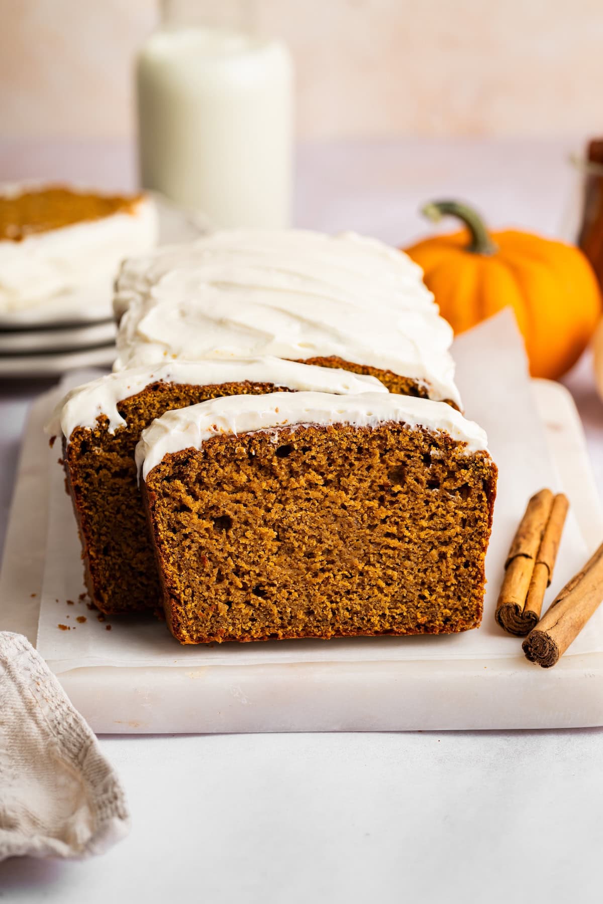 Cottage cheese frosting spread over pumpkin protein bread with an offset spatula.