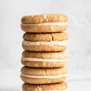 Stack of gluten-free snickerdoodle sandwich cookies filled with cream cheese frosting.