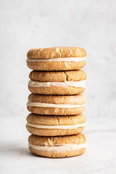 Stack of gluten-free snickerdoodle sandwich cookies filled with cream cheese frosting.
