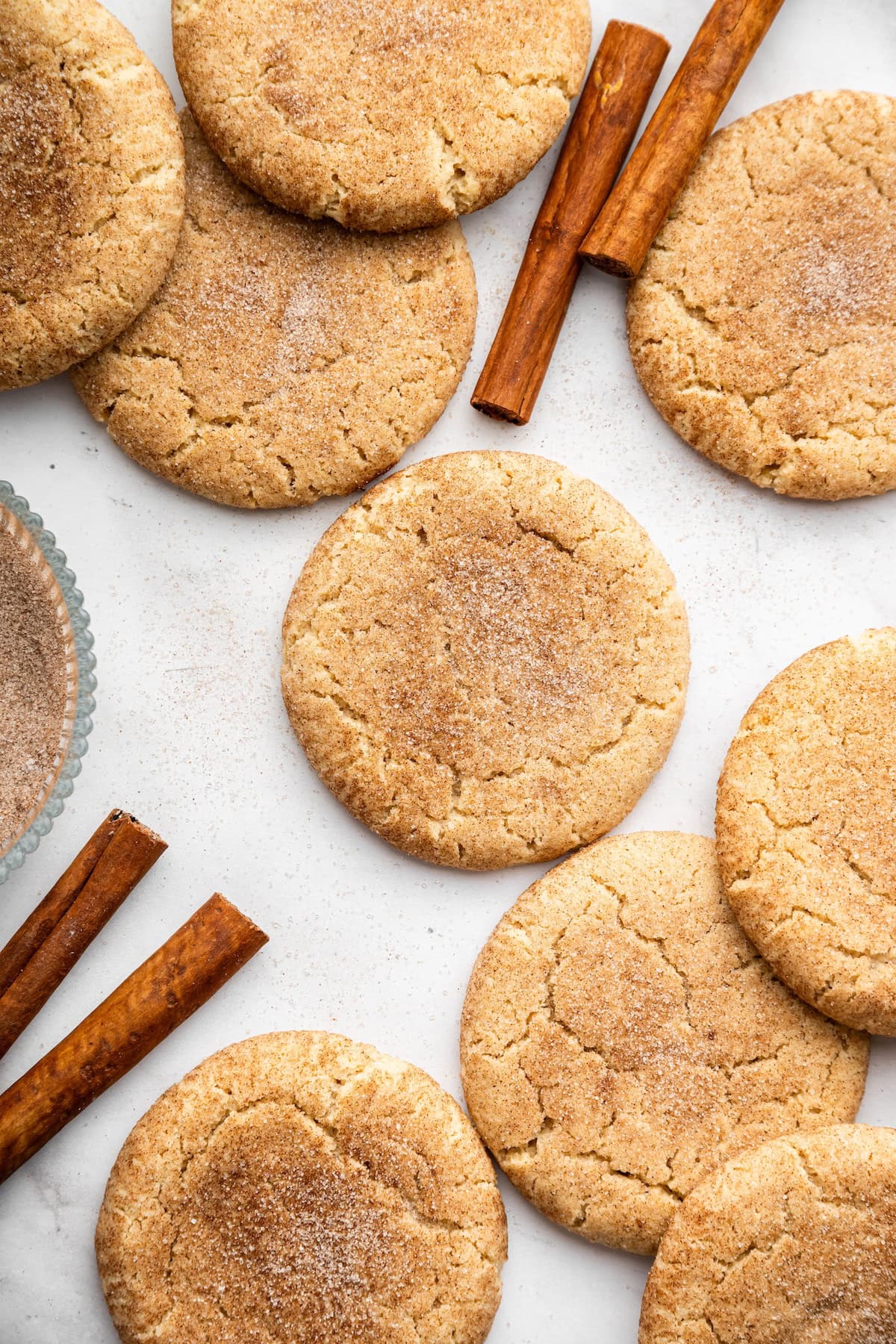 Baked gluten-free snickerdoodle cookies with cinnamon sugar coating on parchment paper.
