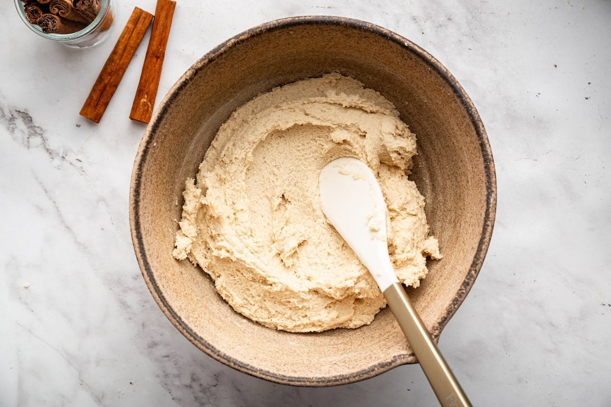 Dry ingredients added to the butter mixture for gluten-free snickerdoodle cookies.
