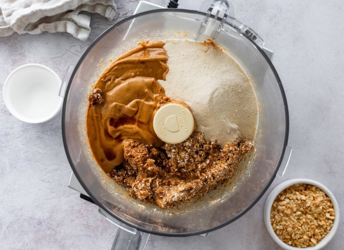 Peanut butter, vanilla protein powder and date mixture in a food processor before blending.