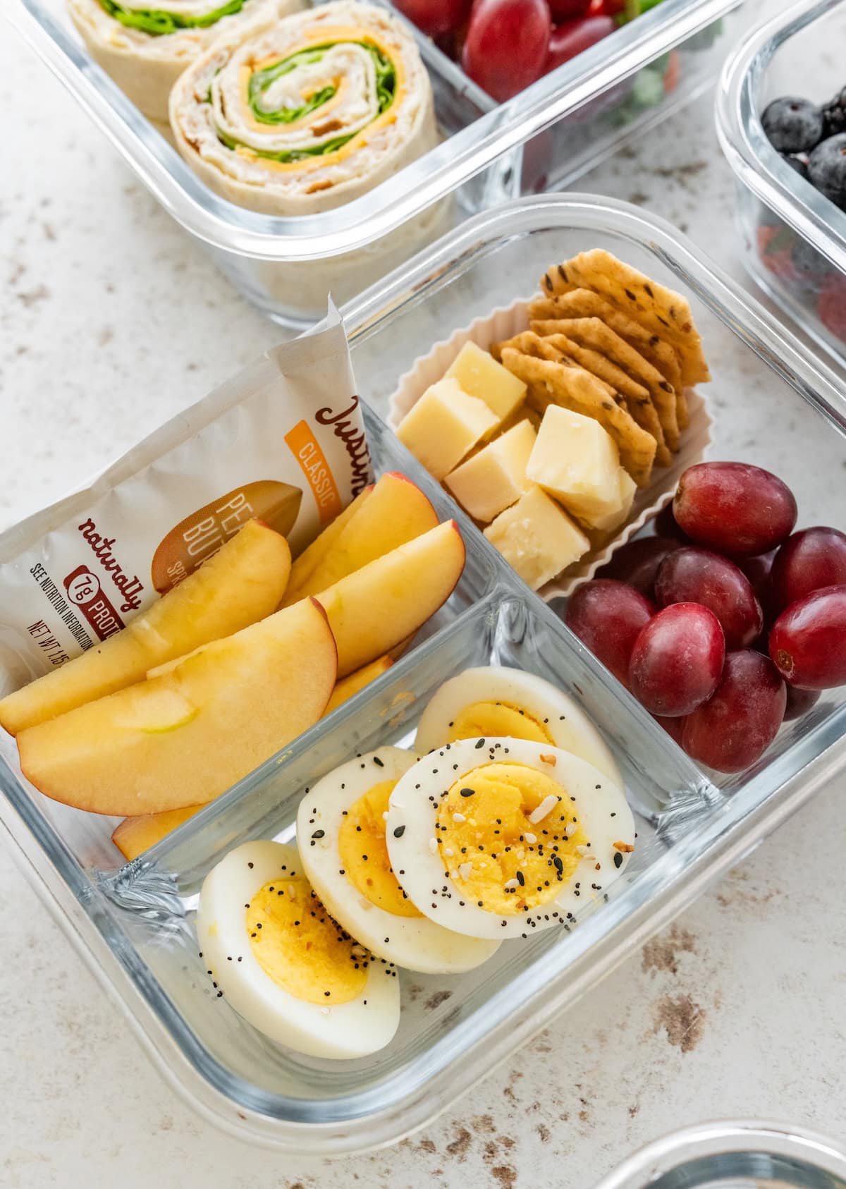 Starbucks copycat protein box with hard-boiled eggs, white cheddar, crackers, apple slices, grapes and a peanut butter packet.